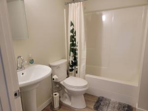a white bathroom with a toilet and a sink at Close to everything in Tacoma! in Tacoma +30 photos