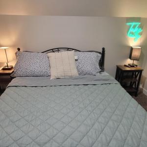 a bedroom with a bed with a blue comforter and two lamps at Close to everything in Tacoma! in Tacoma