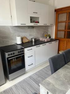 a kitchen with white cabinets and a stove top oven at Apartment Bedem Center in Bihać