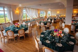 a banquet hall with tables and chairs with flowers on them at The Dark Hedges Hotel in Stranocum
