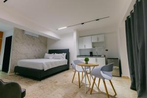 a bedroom with a bed and a table and a kitchen at Arena Aparta Hotel in Punta Cana