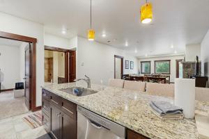 a kitchen with a sink and a living room at Blue River Retreat in Silverthorne
