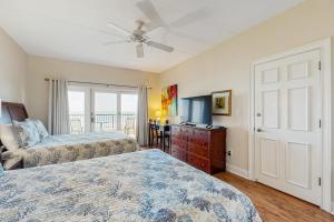 a bedroom with two beds and a ceiling fan at Ocean Front Hotel Side Condo with Balcony, WiFi & Shared Pool in Fernandina Beach