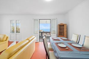 a dining room with a long table and chairs at Caniço Seaview House in Caniço