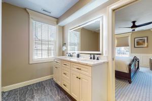 a bathroom with a sink and a mirror and a bed at Steps to Holyoke Medical Center! Remote-Work Hub in Holyoke +14 photos