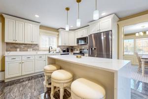 a kitchen with white cabinets and a large island with stools at Steps to Holyoke Medical Center! Remote-Work Hub in Holyoke
