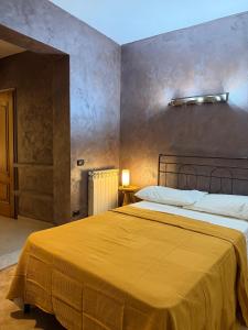 a bedroom with a large bed with a yellow blanket at Villa Mare & Monti in Genoa
