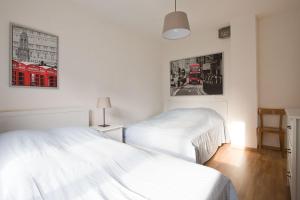 a bedroom with two white beds and a red bus at Casa Onsernone in Comologno in Comologno