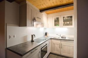 a kitchen with white cabinets and a sink and a stove at Casa Onsernone in Comologno in Comologno +14 photos