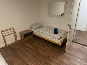 a small bedroom with a bed and a mirror at Central Living Brugg - Studio 12 in Brugg