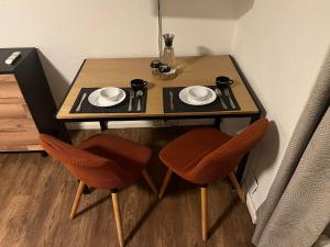 a small table with two chairs and a table with plates and cups at Central Living Brugg - Studio 12 in Brugg