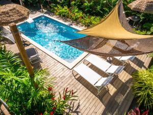 an overhead view of a swimming pool with a hammock and chairs at Coco Soley in Le Diamant
