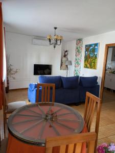 a living room with a table and a blue couch at Apartamento Turístico Dalmacia AT-CC-00769 in Gata