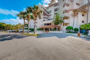 an empty street in front of a building with palm trees at Ocean Front Hotel Side Condo with Balcony, WiFi & Shared Pool in Fernandina Beach