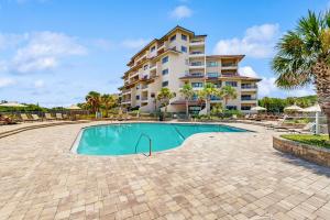 a swimming pool in front of a apartment building at Ocean Front Hotel Side Condo with Balcony, WiFi & Shared Pool in Fernandina Beach