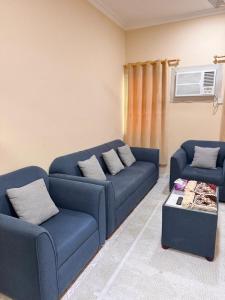 a living room with two blue couches and a table at أجاويد 1 Ajaweed in Salalah +11 photos