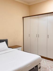 a bedroom with a bed and white cabinets at أجاويد 1 Ajaweed in Salalah