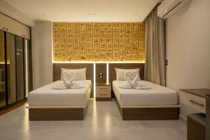 a bedroom with two beds with white sheets at Pyraking Pyramids View Hotel in Giza