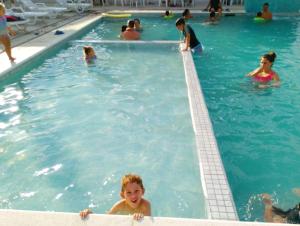 a group of people swimming in a swimming pool at Marechal Plaza Hotel in São Gabriel