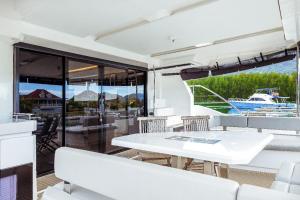 a white table and chairs on a balcony with a boat at Akula Catamaran - N4 Charters Seychelles in Victoria