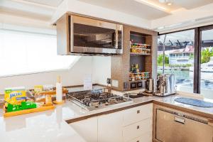 a kitchen with a stove top oven next to a window at Akula Catamaran - N4 Charters Seychelles in Victoria