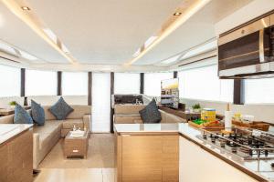 a kitchen and a living room with a couch at Akula Catamaran - N4 Charters Seychelles in Victoria