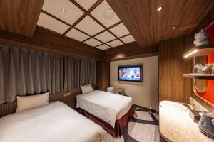 a hotel room with two beds and a flat screen tv at Hotel Keihan Asakusa in Tokyo +101 photos