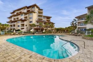 a swimming pool in front of a apartment building at Ocean Front Hotel Side Condo with Balcony, WiFi & Shared Pool in Fernandina Beach