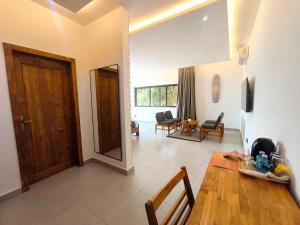 a living room with a wooden door and a table at Résidence Ermitage in Ouidah