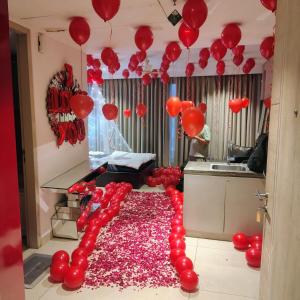 a room with red balloons and a table with a bunch of balloons at Luxury Studios Key 1 in Gurgaon
