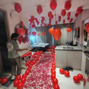a man standing in a kitchen with red balloons at Luxury Studios Key 1 in Gurgaon