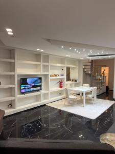 a living room with a white table and a tv at Villa Mare & Monti in Genoa