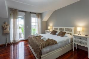 a bedroom with a bed and a large window at Los cuetos, casa para 6 personas con jardín y parking, a pocos minutos de Suances in Suances +13 photos