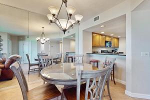 a dining room and kitchen with a table and chairs at Oceanfront condo with panoramic views, shared pool, and private washer & dryer in Fernandina Beach