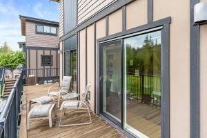 a balcony with two chairs and a sliding glass door at Wild Beauty - Oceanview - Pet Friendly - sleep 2 in Port Renfrew