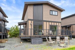 a house with a deck and chairs in front of it at Wild Beauty - Oceanview - Pet Friendly - sleep 2 in Port Renfrew +17 photos