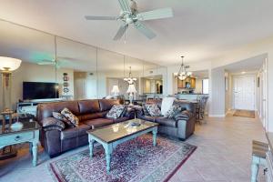a living room with a couch and a table at Oceanfront condo with panoramic views, shared pool, and private washer & dryer in Fernandina Beach