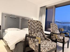 a bedroom with a bed and two chairs at Luxe jacuzzi studio key 2 in Gurgaon +28 photos