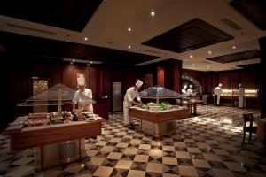 a restaurant with two chefs preparing food in a room at Stella Di Mare Beach Hotel & Spa in Sharm El Sheikh