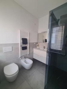 a white bathroom with a toilet and a sink at Corte del Gallo in Legnano +5 photos