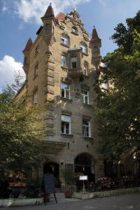een hoog stenen gebouw met een toren bij Hotel Mariandl in München