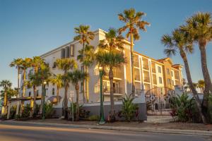 a building with palm trees in front of a street at Castillo Real St Augustine Beach,Tapestry Collection Hilton in Saint Augustine Beach