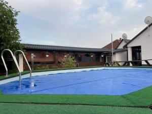 a swimming pool in a backyard with a blue at Ádi Vendégház - Bekecs in Bekecs
