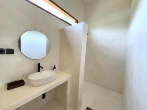 a bathroom with a white sink and a mirror at Sola Rooms in Kuta Lombok