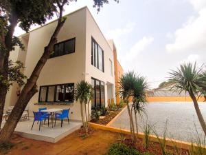 a house with a table and chairs in front of it at Résidence Ermitage in Ouidah