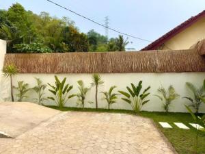 a wall with a mural of palm trees on it at Sola Rooms in Kuta Lombok