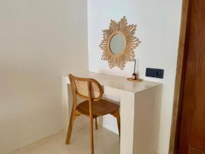 a desk with a chair and a mirror on a wall at Sola Rooms in Kuta Lombok