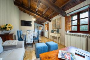 a living room with blue chairs and a table at Aldea A Paínza in Arzúa
