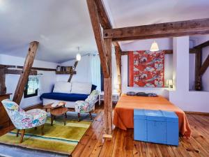 a bedroom with a bed and a blue couch at Large holiday home, summer pool, sauna, whirlpool in Sasino