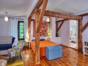 a bedroom with a bed and a chair and wooden beams at Large holiday home, summer pool, sauna, whirlpool in Sasino